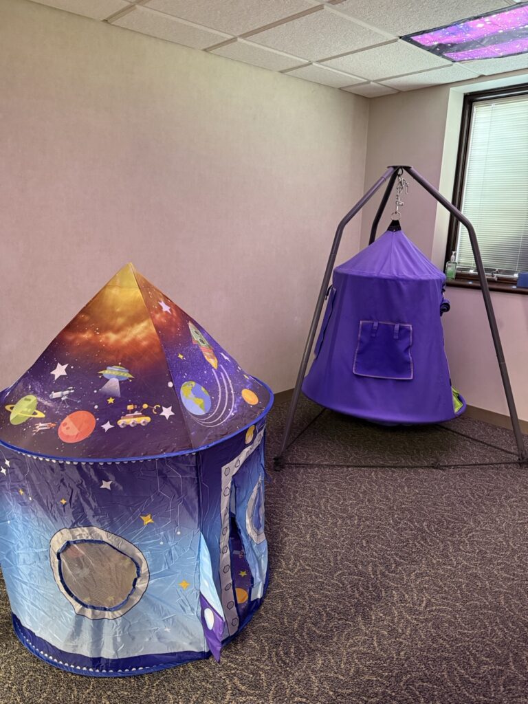 Sensory corner with a space-themed play tent and a hanging swing pod