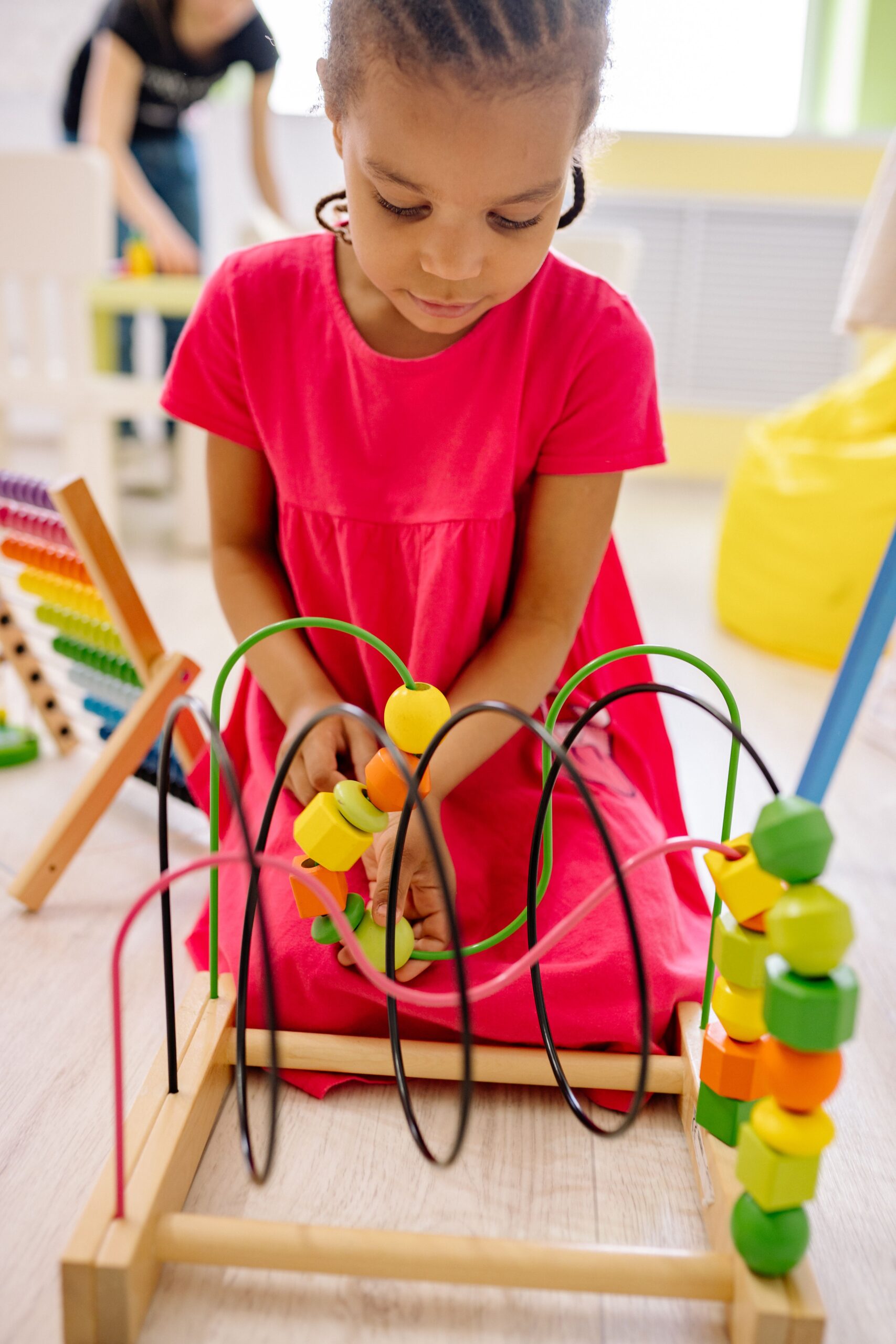 Child exploring a colorful bead maze during a play activity